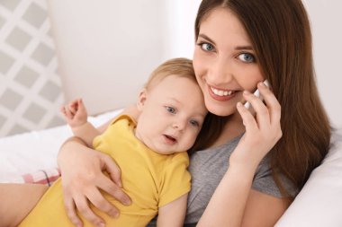 Genç anne bebek yatakta evde çalışma ile