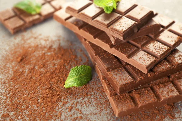 Tasty chocolate with mint on gray background