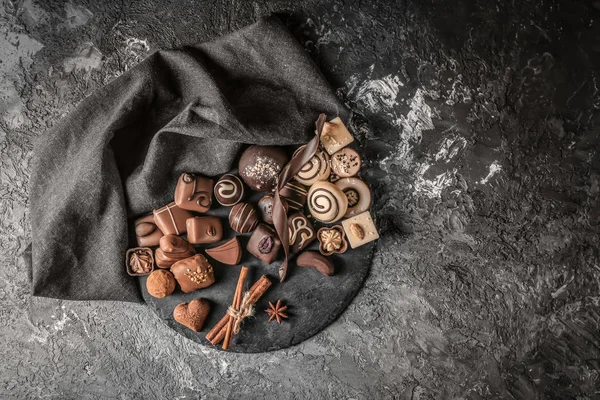 Placa Ardósia Com Diferentes Doces Chocolate Saborosos Mesa Texturizada — Fotografia de Stock