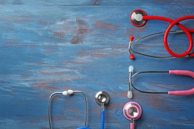Stetoskoplar renk ahşap arka plan üzerinde. Sağlık kavramı