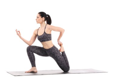 Beyaz arka planda yoga yapan genç bir kadın.