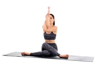 Beyaz arka planda yoga yapan genç bir kadın.