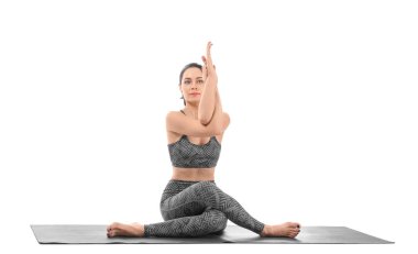 Beyaz arka planda yoga yapan genç bir kadın.