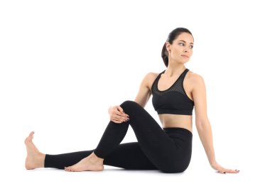 Beyaz arka planda yoga yapan genç bir kadın.