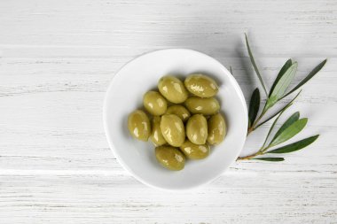 Ahşap masa üzerinde konserve zeytin ile plaka