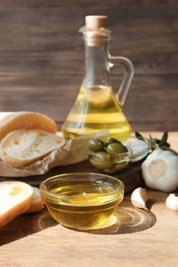 Zeytin yağı ile taze ekmek ve ahşap masa sarımsak şişe