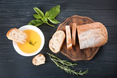 Zeytin yağı ile taze ekmek ve otlar masada, üstten görünüm