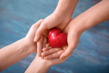 Kırmızı kalp tutan kadınlar arka planını renklendirin. Sağlık kavramı