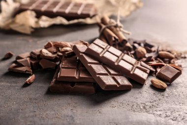 Sütlü çikolata parçaları ile badem gri arka plan üzerinde