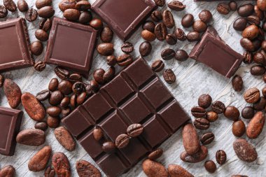 Hafif dokulu arka plan üzerinde kahve çekirdekleri ile çikolata parçaları