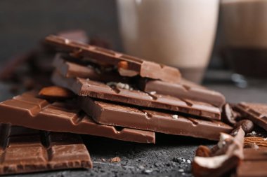 Sütlü çikolata parçaları ile birlikte koyu arka planda, tatlı badem