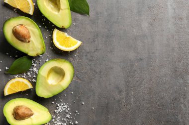Taze avokado ve limon dilimleri gri arka plan üzerinde kesmek
