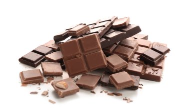 Lezzetli süt ve beyaz arka plan üzerinde koyu çikolata parçaları