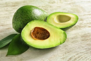 Ahşap arka plan üzerinde olgunlaşmış avokado