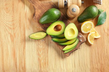 Ahşap arka plan üzerinde olgunlaşmış avokado ile kompozisyon