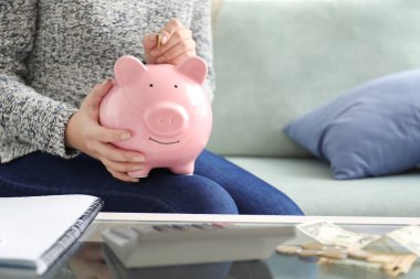 Kumbara kapalı para koyarak kadın. Para tasarruf kavramı