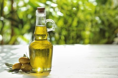 Cam sürahi taze yağı ve masada açık havada konserve zeytin ile