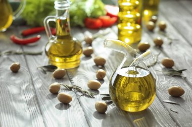 Ahşap masa üzerinde taze zeytin yağı ile şişe