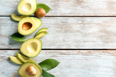 Hafif ahşap arka plan üzerinde olgunlaşmış avokado ile kompozisyon