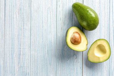 Hafif ahşap arka plan üzerinde olgunlaşmış avokado