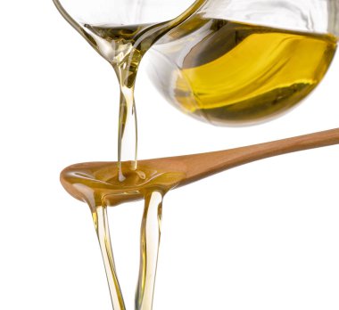 Zeytinyağı cam sürahi gelen beyaz zemin üzerine kaşık dökme