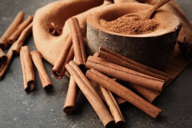 Toz tarçın ve gri arka plan üzerinde sopa ile kompozisyon