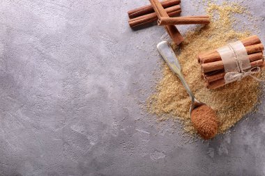 Tarçın ve şeker gri arka plan üzerinde kompozisyonu