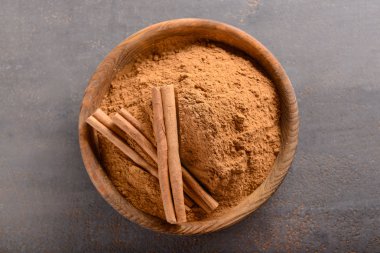 Gri arka plan, üstten görünüm üzerinde toz tarçın ile kase