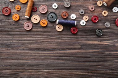 Farklı düğmeler ve ahşap arka plan iş parçacığı