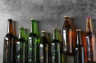 Taze bira gri arka plan üzerinde cam şişelerde