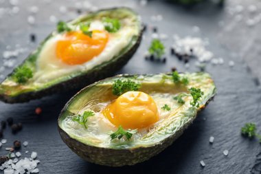 Tablo üzerinde yumurta ile pişmiş avokado