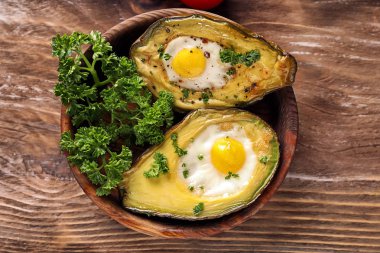 Ahşap arka plan üzerinde yumurta ile pişmiş avokado