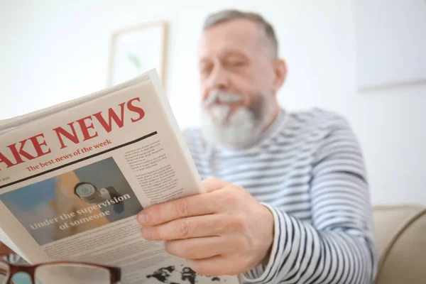 老人は家で新聞を読んでいる — ストック写真