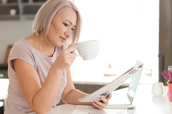 Mature Woman Drinking Coffee While Reading Newspaper Home — Stock Photo, Image