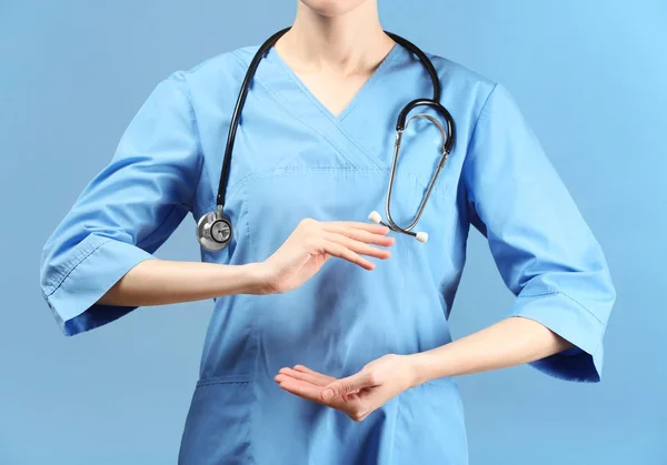 Médica Feminina Segurando Algo Fundo Cor — Fotografia de Stock