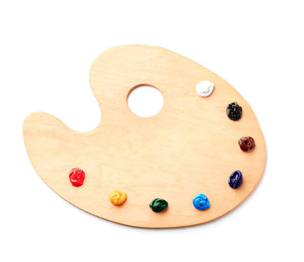 Wooden palette with paints on white background