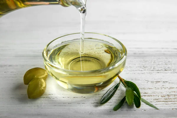 Pouring Olive Oil Bottle Glass Bowl Wooden Table — Stock Photo, Image