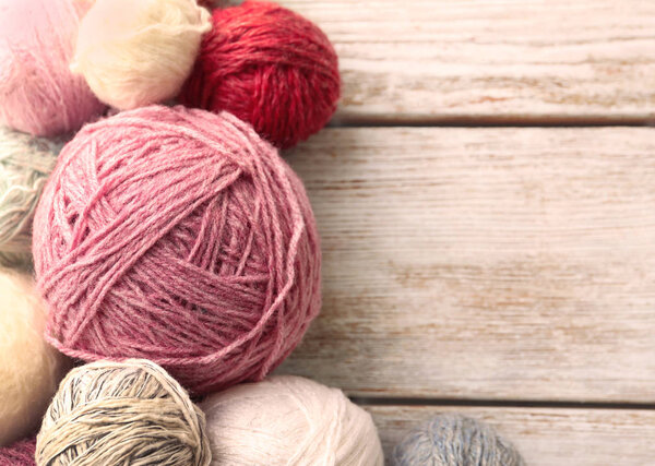 Balls of knitting yarn on wooden background