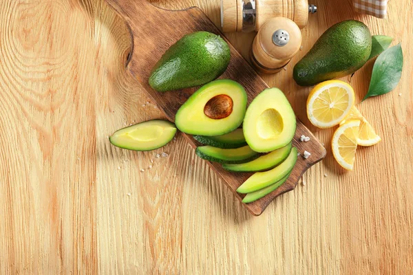 Ahşap arka plan üzerinde olgunlaşmış avokado ile kompozisyon