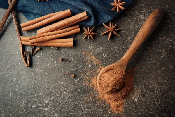 Composition with cinnamon and spices on grey background