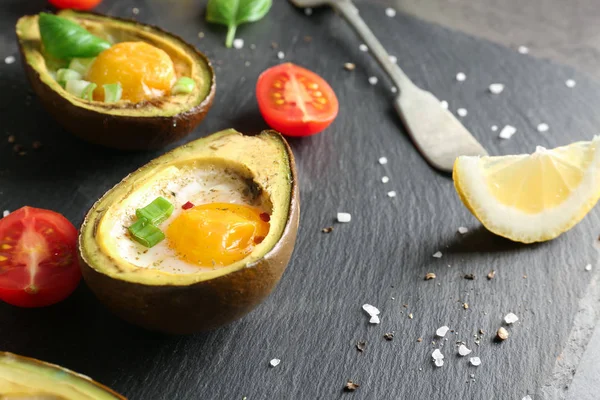 Avocado baked with eggs on table