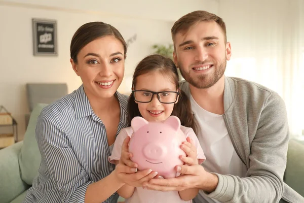 Niña Feliz Con Sus Padres Sosteniendo Alcancía Interior Concepto Ahorro —  Fotos de Stock