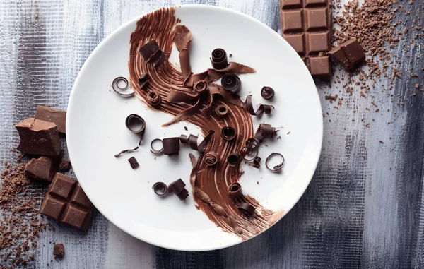 Plate with delicious chocolate curls on table