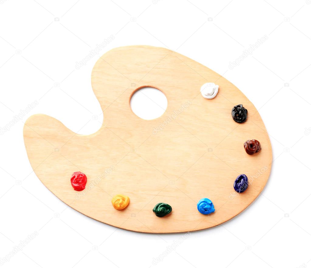Wooden palette with paints on white background