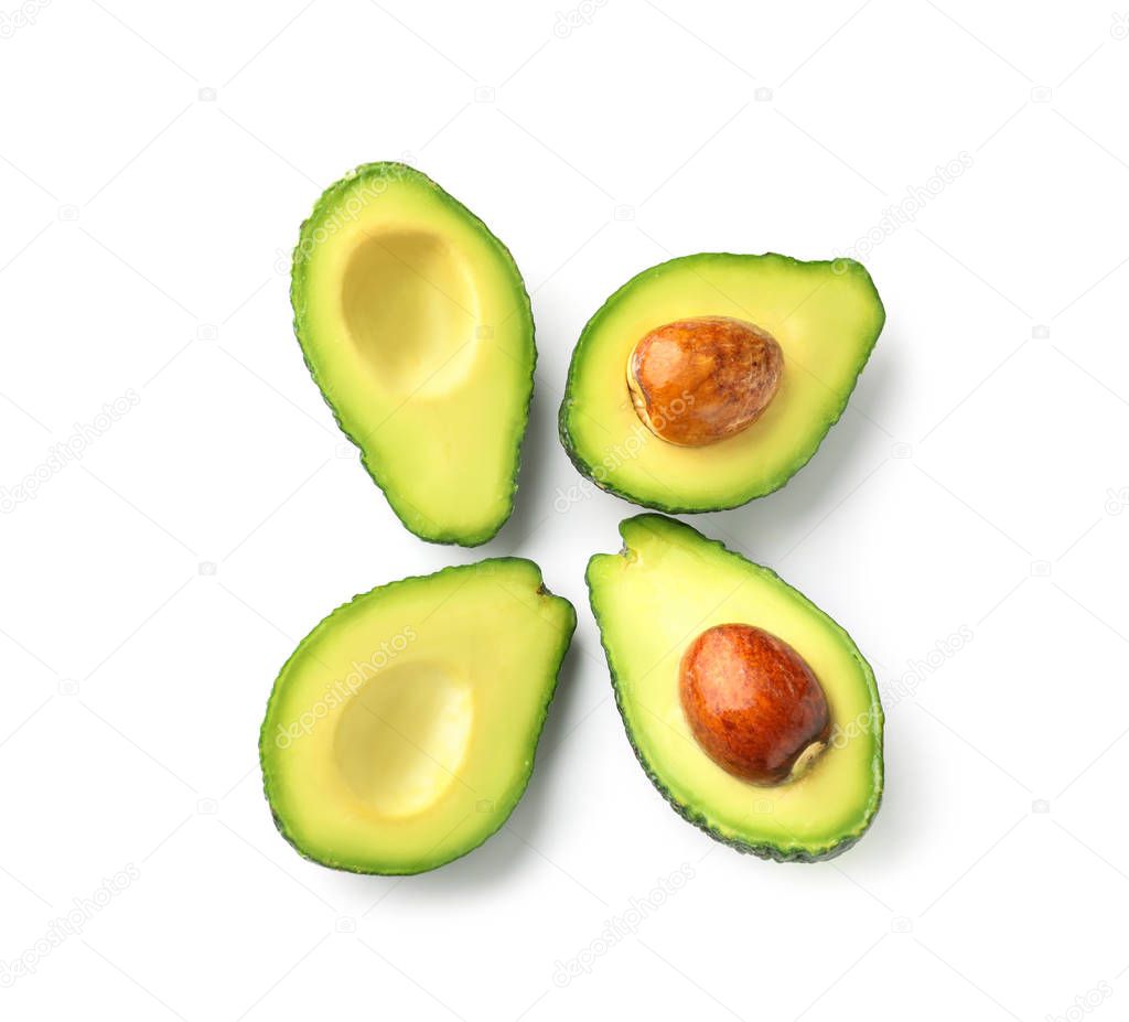 Halves of fresh avocados on white background