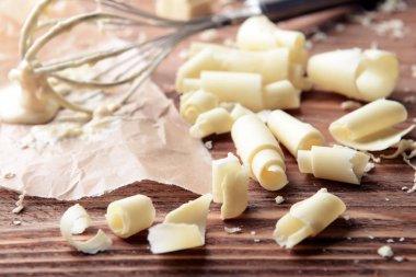 Beyaz çikolata masada çırpma teli ile bukleler