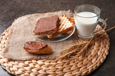 Çikolatalı hamur ve fincan süt hasır mat ile kızarmış ekmek