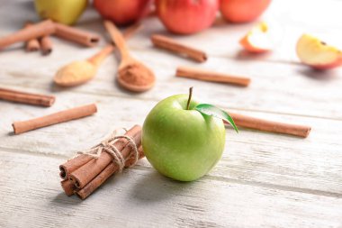 Taze elma ve tarçın ahşap arka plan üzerinde