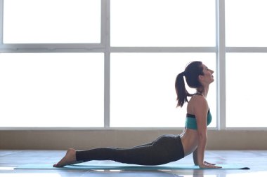 Evde yoga yapan genç bir kadın.