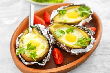 Ahşap masa, closeup üzerinde avokado pişmiş yumurta ile plaka